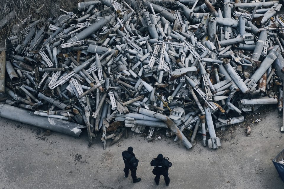Policajti si prezerajú zhromaždené úlomky ruských rakiet, ktoré zasiahli Charkiv. Foto - tasr/ap