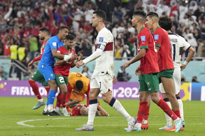 Marockí hráči oslavujú po výhre nad Portugalskom, zatiaľ čo Cristiano Ronaldo (uprostred) odchádza z ihriska. FOTO TASR/AP