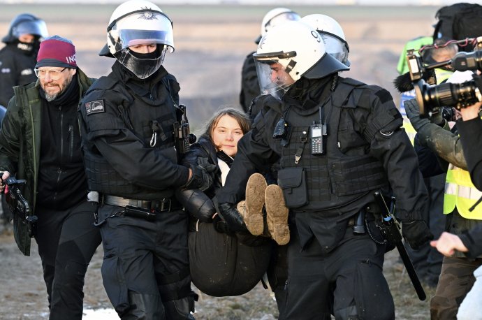 Policajti odnášajú z klimatického protestu Gretu Thunberg. Foto - TASR/AP