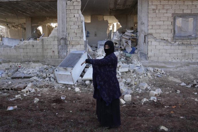 Ayesha stojí pred svojím zrúteným domom v sýrskom meste Atareb. "Bolo by lepšie, keby som tam zomrela. Von som vyšla s tým, že som na pleciach niesla sutiny celého sveta," povedala. Zdroj - TASR/AP