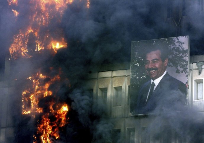 Portrét Saddáma Husajna na horiacej budove ministerstva dopravy v Bagdade. Foto - TASR/AP