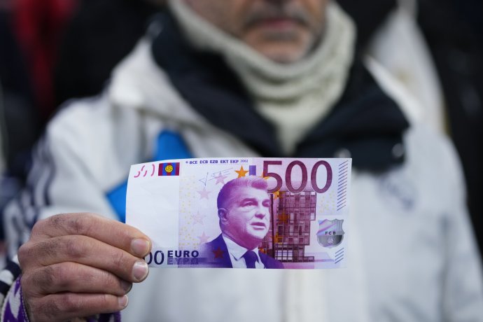 Fanúšik Realu Madri drží falošnú 500-eurovú bankovku s podobizňou prezidenta FC Barcelona Joana Laportu ako symbolickú kritiku korupčnej rozhodcovskej kauzy klubu. Foto - TASR/AP