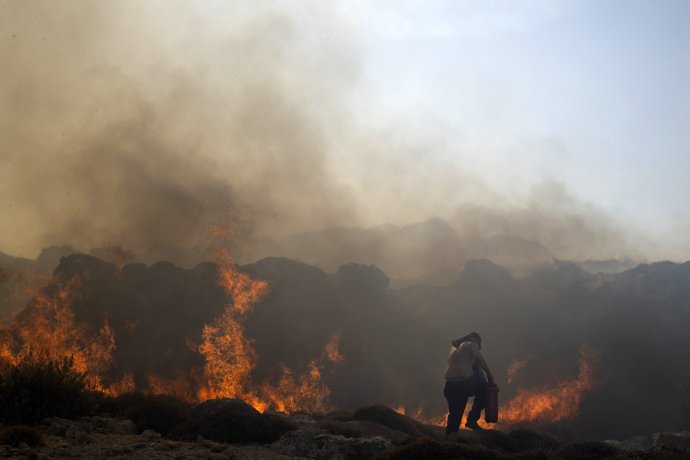 Hasič pri požiari neďaleko rezortu Lindos na Rodose v pondelok 24. júla. Foto – TASR/AP