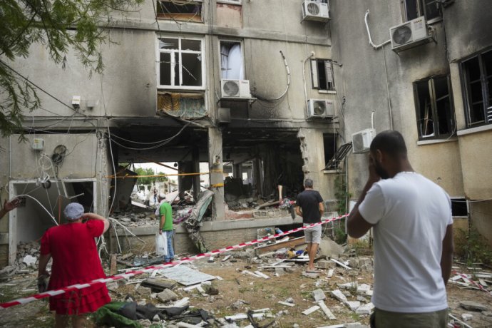 Izraelčania kontrolujú poškodenú obytnú budovu po zásahu raketou vypálenou z pásma Gazy v izraelskom meste Aškelon 9. októbra 2023. Foto: TASR/AP