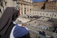 Mníška sleduje z terasy svätú omšu, ktorú celebruje pápež František pri príležitosti začiatku biskupskej synody na Námestí sv. Petra vo Vatikáne. Foto - TASR/AP