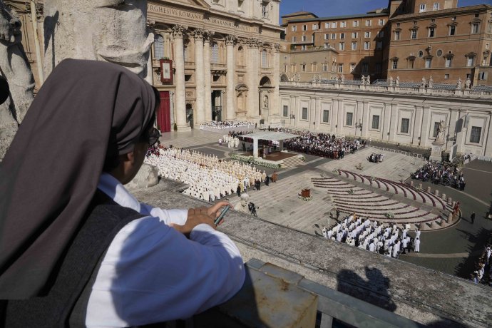 Mníška sleduje z terasy svätú omšu, ktorú celebruje pápež František pri príležitosti začiatku biskupskej synody na Námestí sv. Petra vo Vatikáne. Foto - TASR/AP