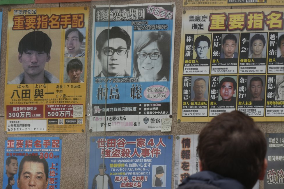 Hľadaný Satoši Kirišima v strede hore na modrom policajnom plagáte. Foto - TASR/AP