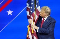 Donald Trump bozkáva vlajku na sobotňajšom konzervatívnom podujatí v Marylande. Foto - TASR/AP